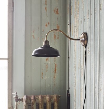 Vägglampa Birgith Svart från Strömshaga på träpanelvägg