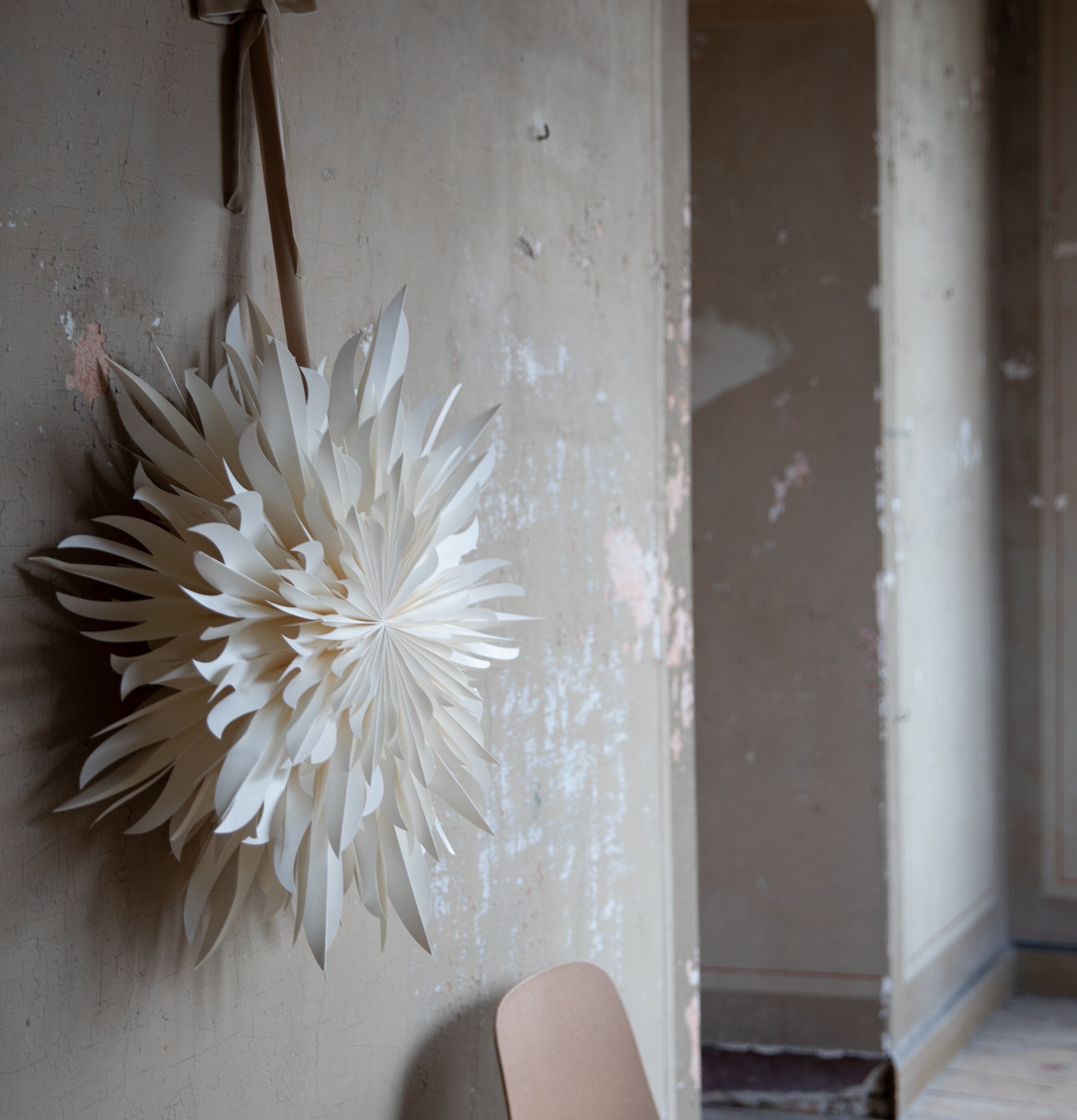 Julstjärna Eldig 52 White från Watt och Veke på sliten vägg