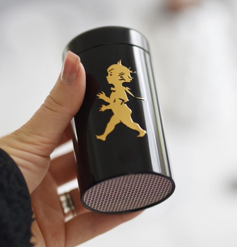 Solstickan Tändsticksrör Svart/Guld hålls i en hand