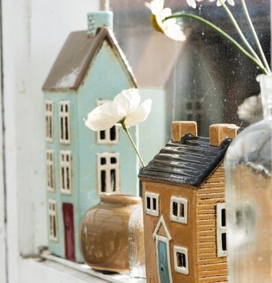 Bild av charmiga ljuslyktor och blommor i fönster