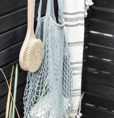 Nätkasse IB Laursen hänger på svart trävägg med borste