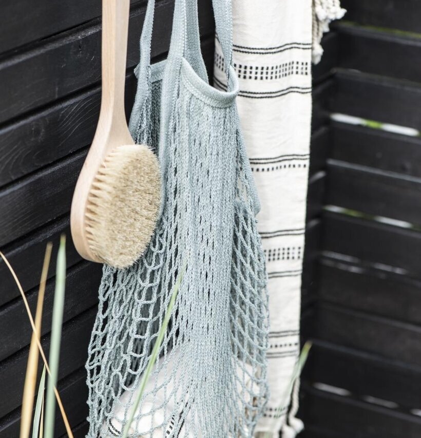 Nätkasse IB Laursen hänger på svart trävägg med borste