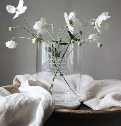 Bild av elegant vas med vita blommor och träbricka