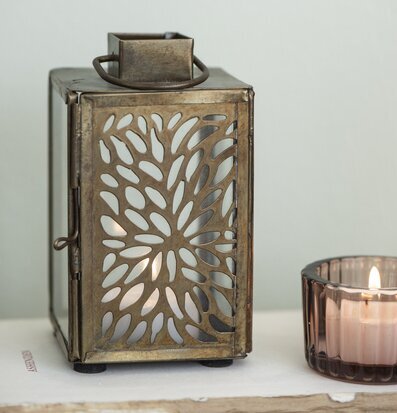 Foto av ljuslykta med rustik design och guldtoner