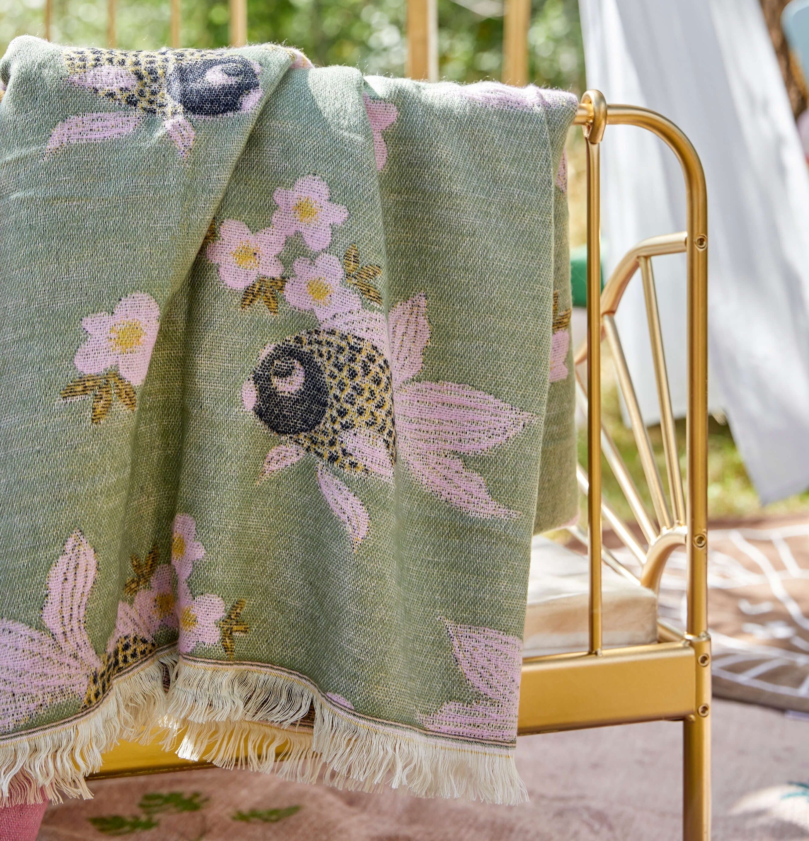 Pläd Goldfish Sage Green från Rice i trädgårdsmiljö