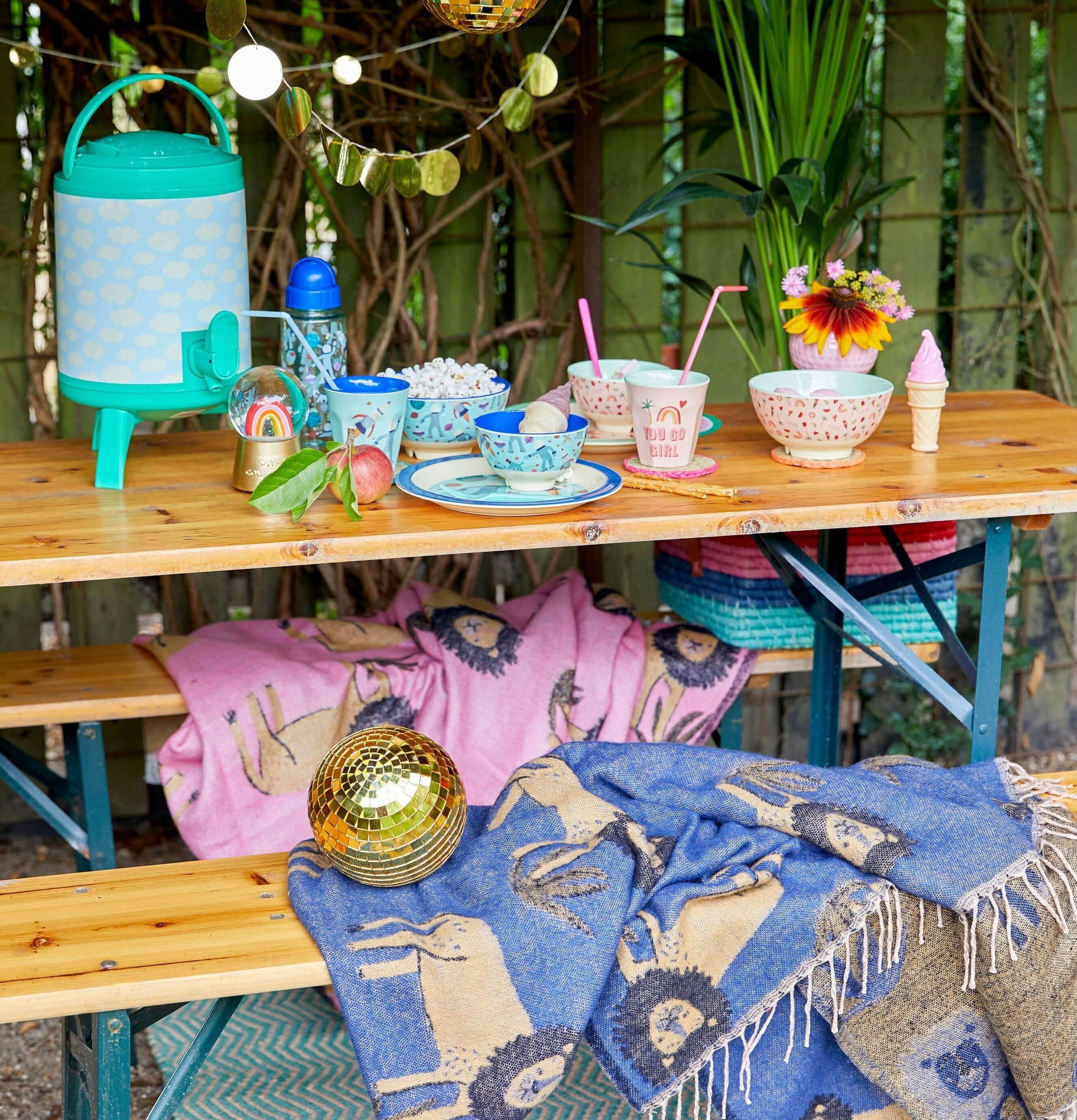 Pläd Lions Bubblegum Pink från Rice på en picknickbänk