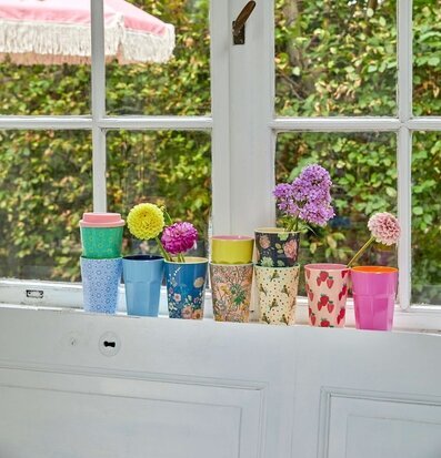 Foto av färgglad fönsterbräda med muggar och blommor