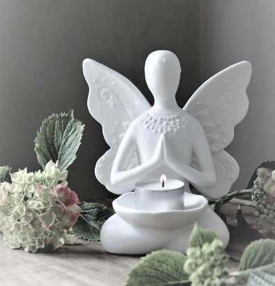 Foto av elegant ljushållare med meditativ figur