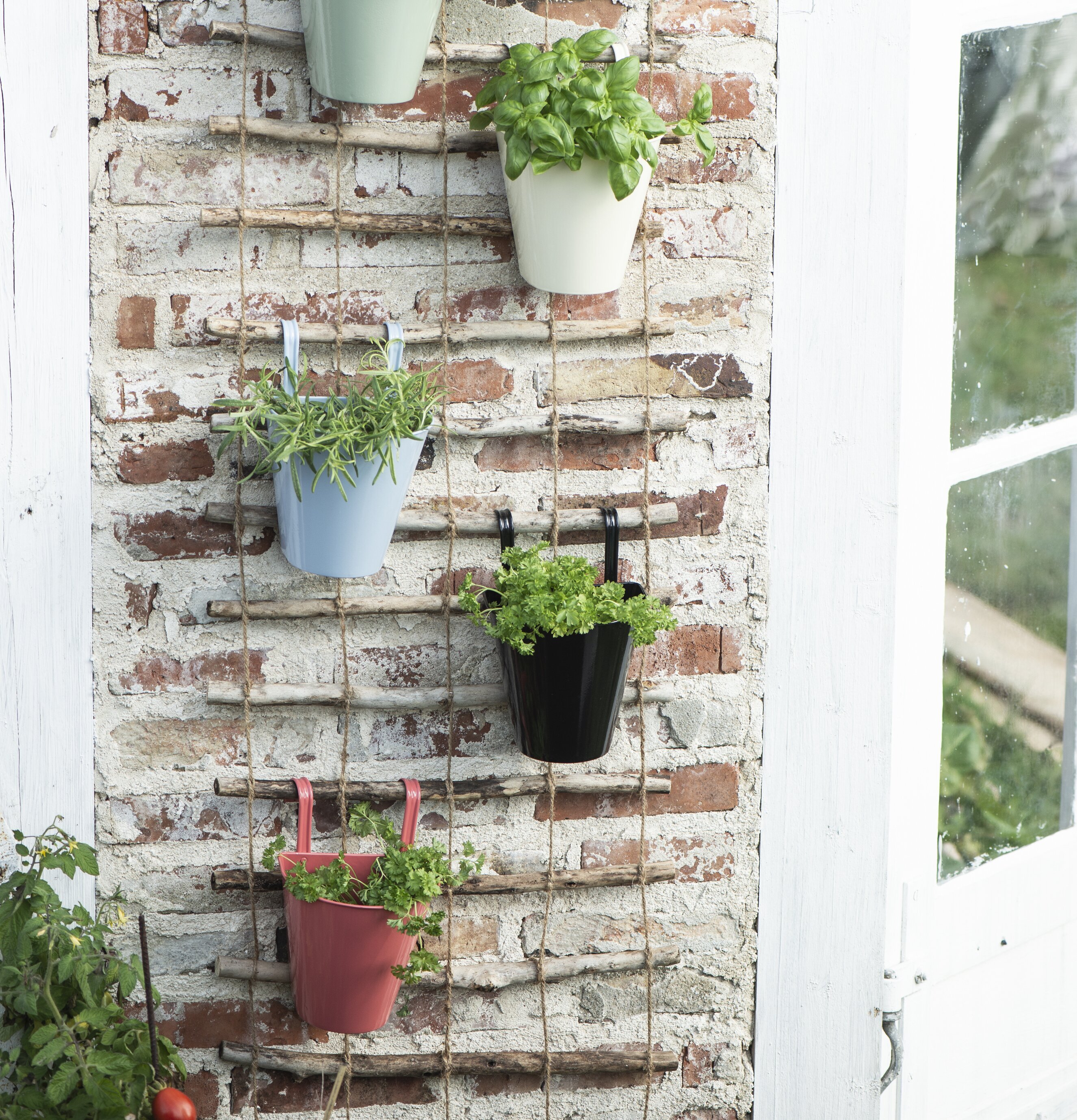 Väggkruka Senapsgul från IB Laursen på rustik tegelvägg