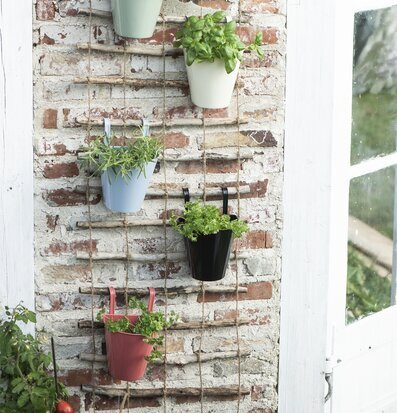 Väggkruka Senapsgul från IB Laursen på rustik tegelvägg