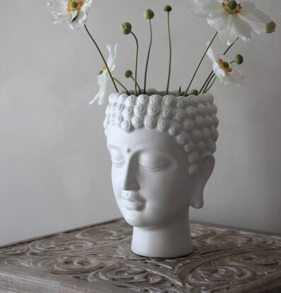 Kruka Buddha - Majas Cottage på snidat träbord med blommor