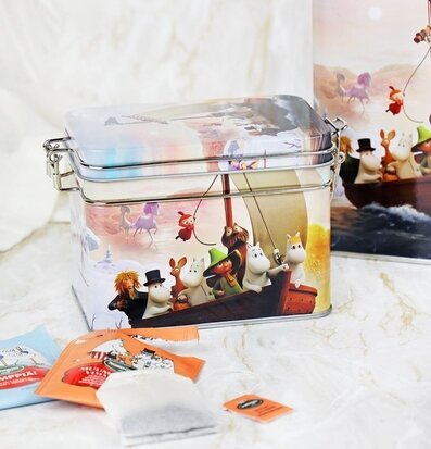 Bild av färgglad teburk med Muminmotiv och solnedgång