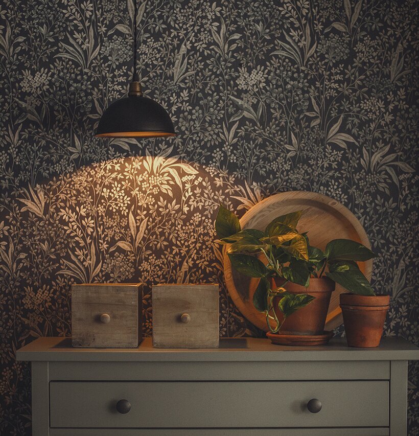 Taklampa Pelle Svart från Strömshaga över en grå byrå