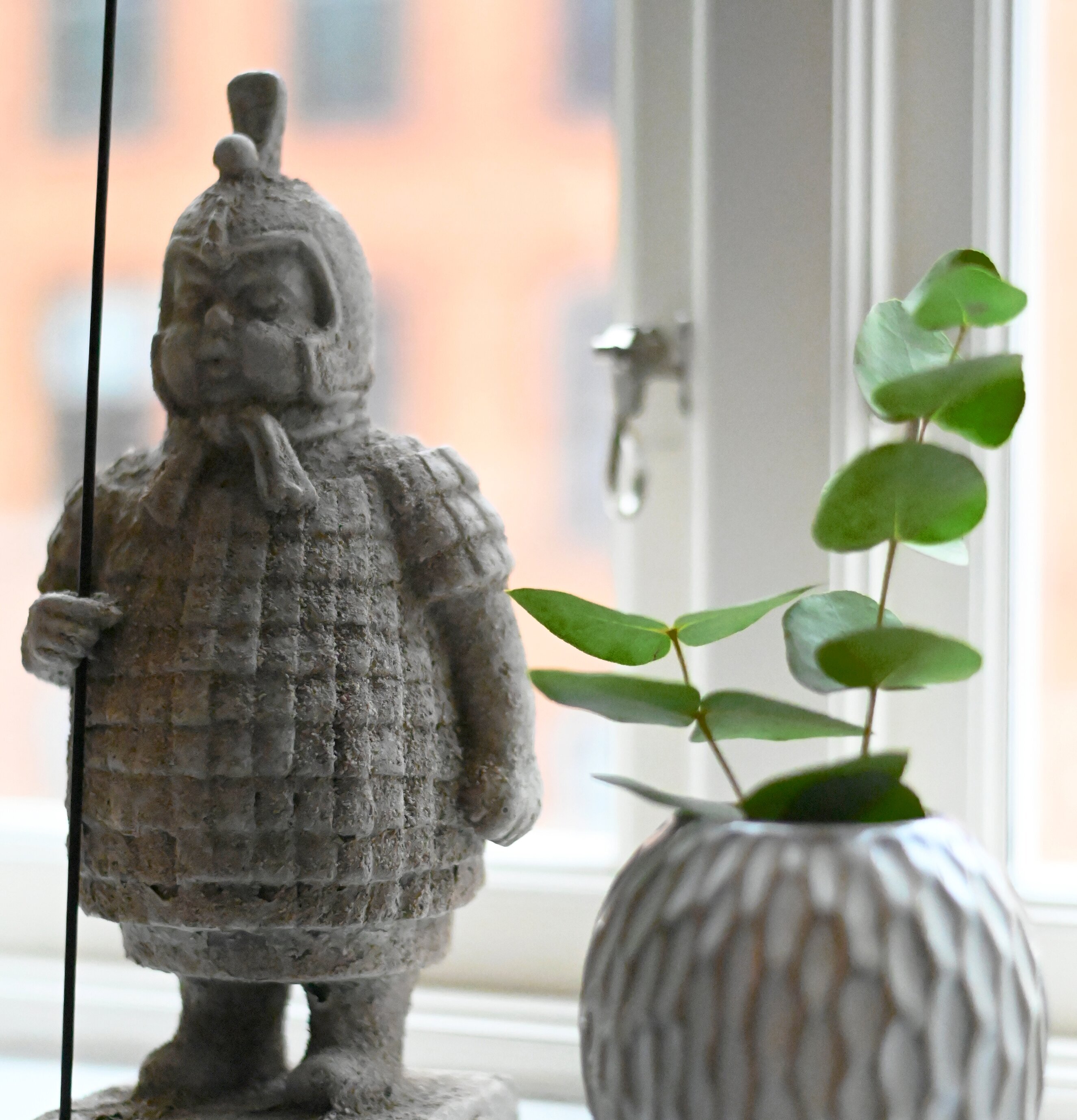 Statue Knekt Large från Miljögården på fönsterbräda med vas