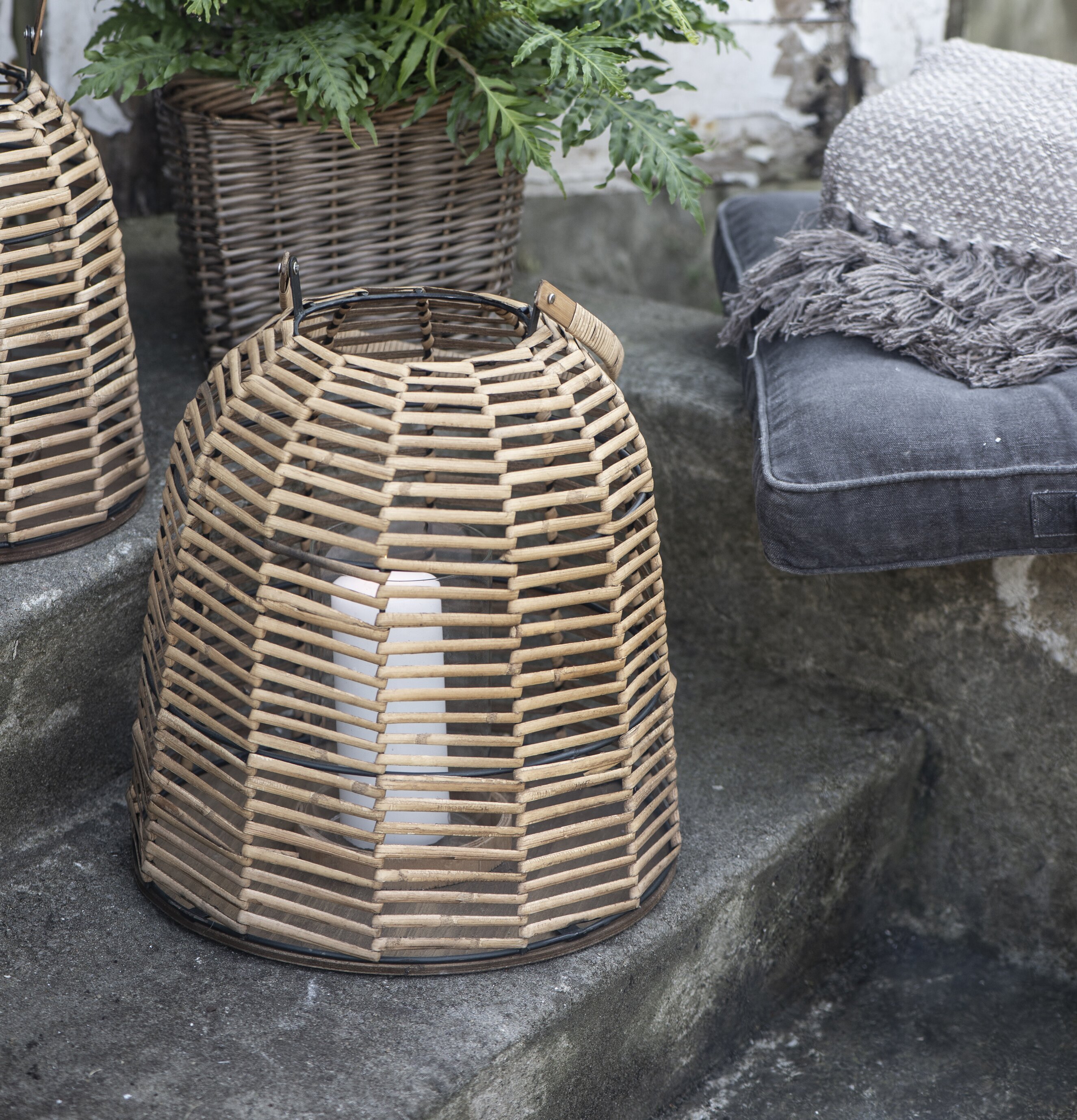 Bild av harmonisk utemiljö med ljuslykta i rotting