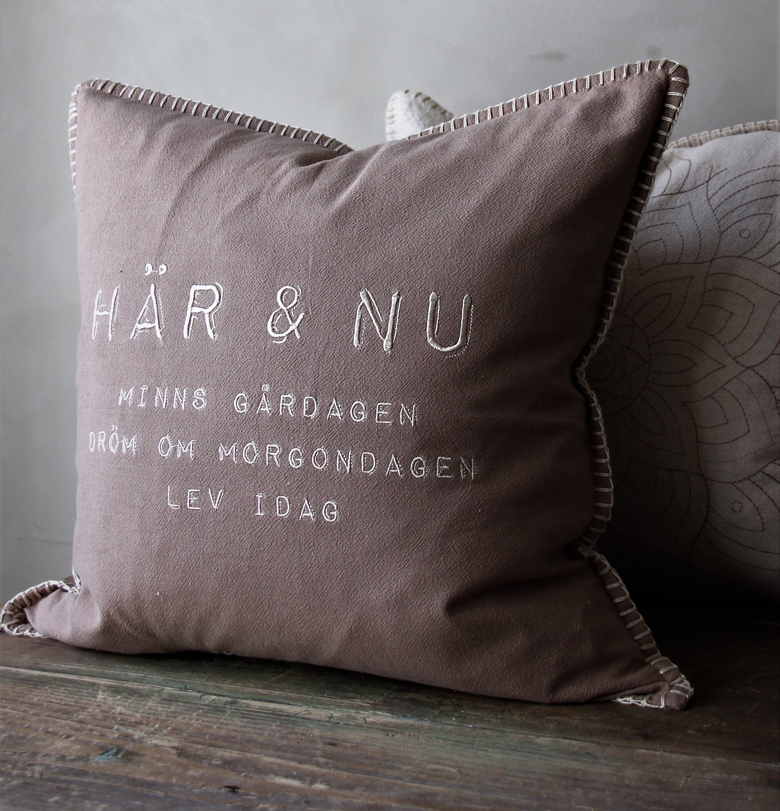 Kudde Här & Nu Taupe från Majas Cottage på rustik trämöbel
