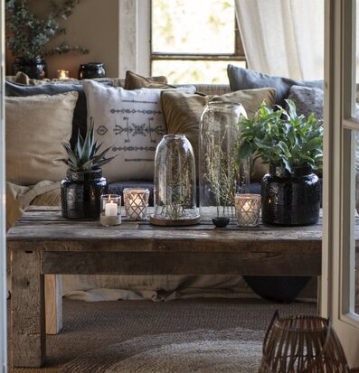 Glasklocka från IB Laursen på rustikt träbord med växter