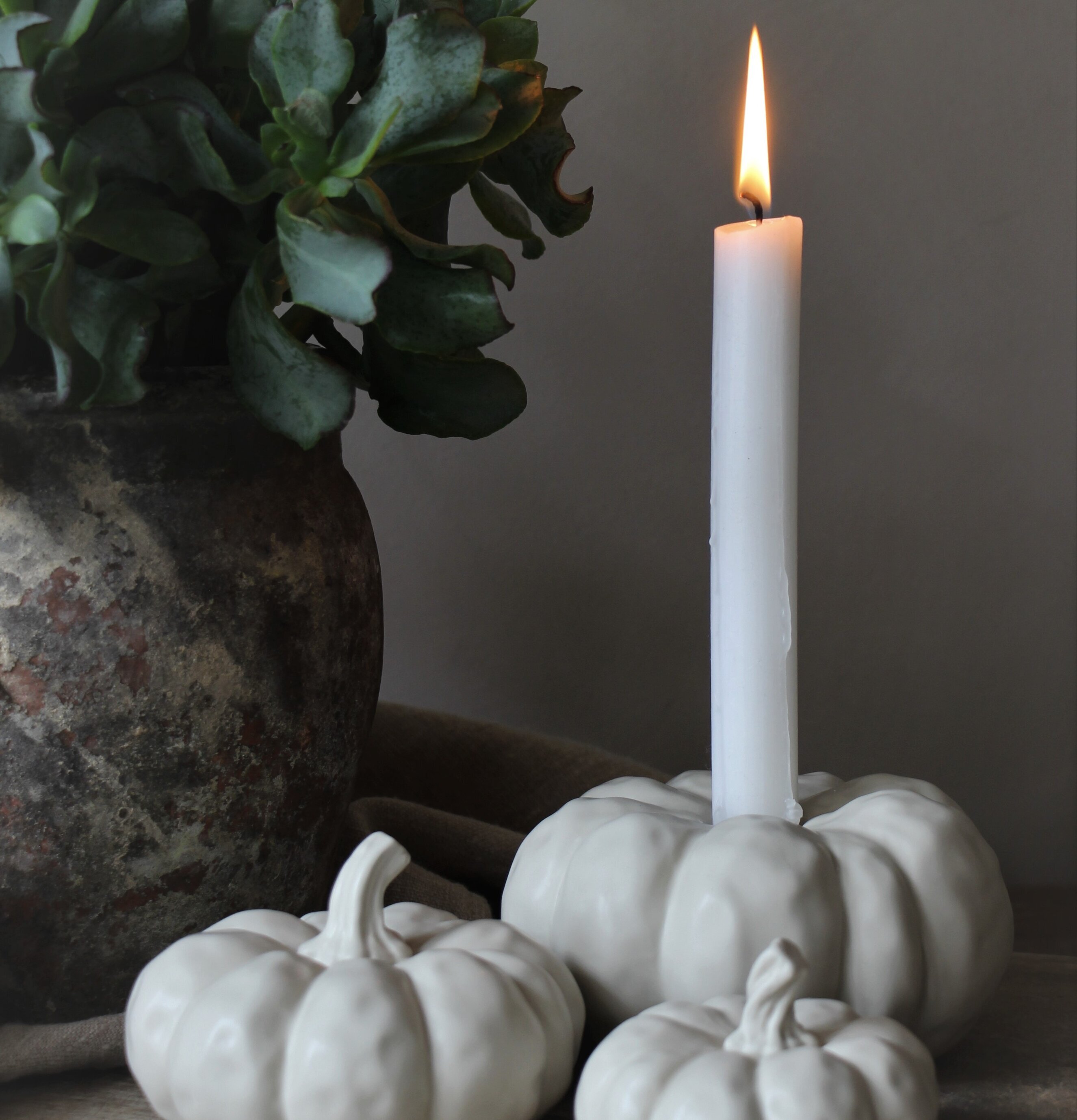 Ljuslykta Pumpa Beige från Majas Cottage på träyta med växt