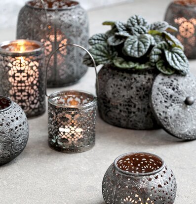 Bild av dekorativa lyktor och frodig krukväxt