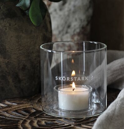 Bild av dekorativ scen med ljuslykta och grönt bladverk