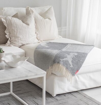 Pläd Ljusgrå Solstickan från Solstickan draperad över divan