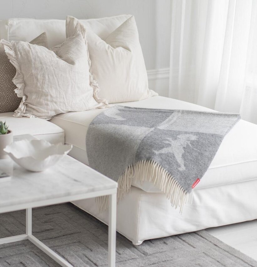 Pläd Ljusgrå Solstickan från Solstickan draperad över divan