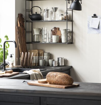 Tallrikshållare från IB Laursen på mörk arbetsbänk i kök