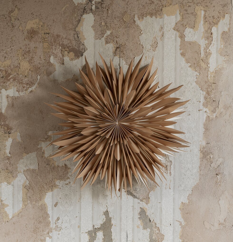 Julstjärna Maja 60 Guld från Watt och Veke på rustik vägg