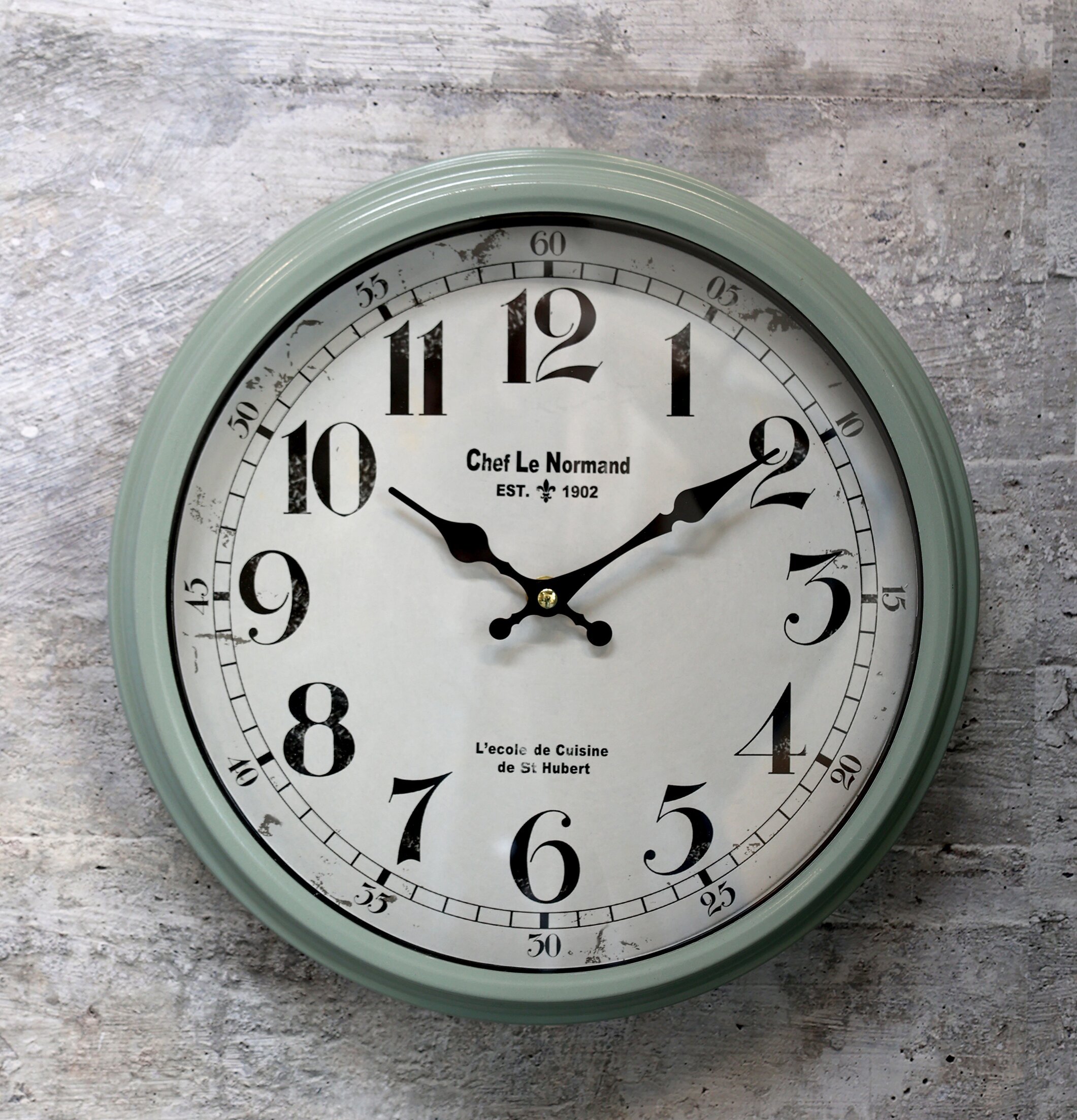 Väggklocka Verte från Chic Antique mot grå betongvägg