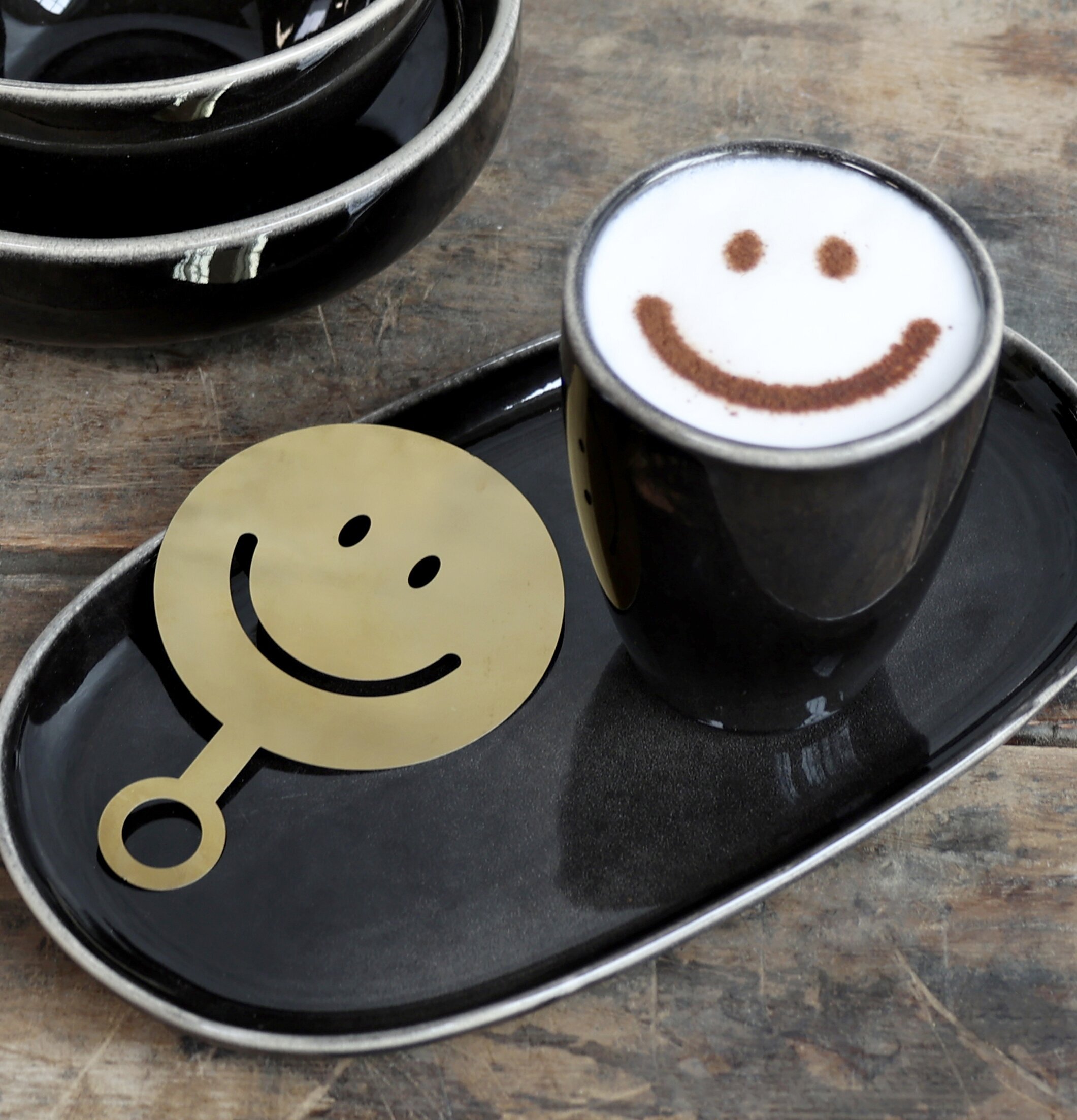 Kaffestencil Smiley från Chic Antique på ett träbord