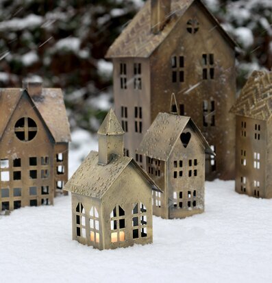 Bild av ljuslyktor formade som hus i vinterlandskap