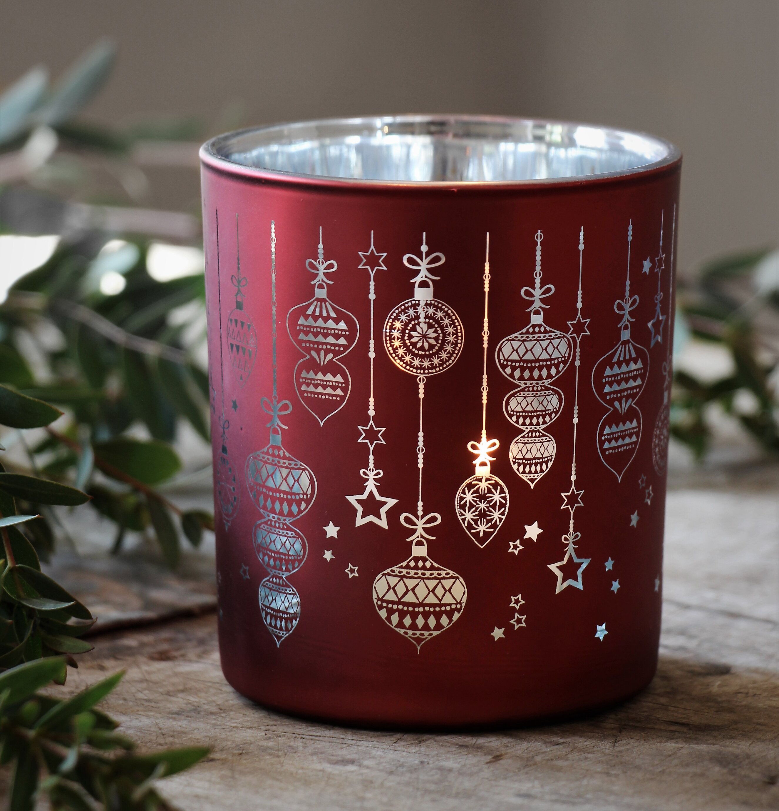 Bild av ljuslykta med julmotiv i rött och silver