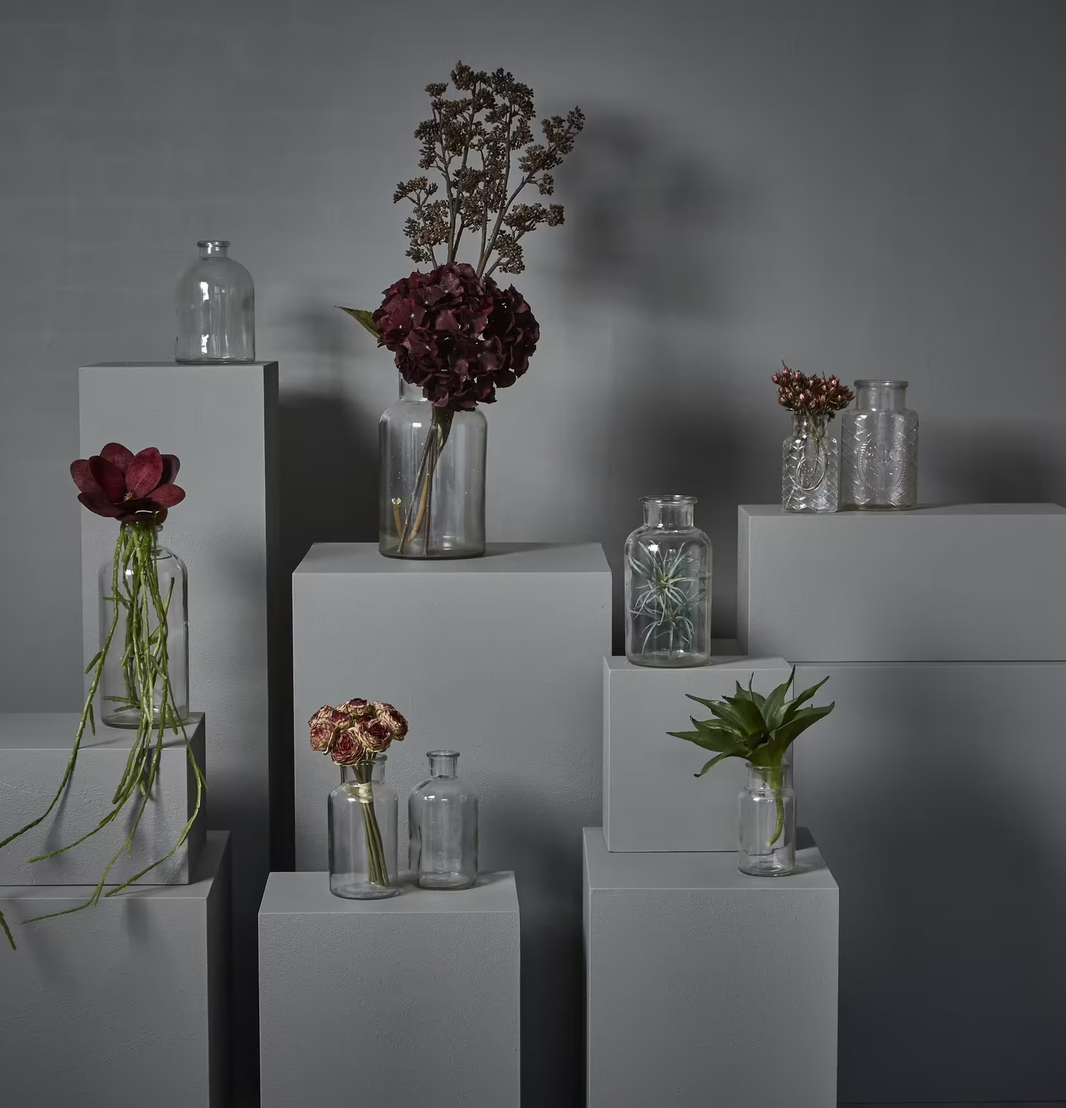 Dekorationsglas Stor från Speedtsberg på vita podier med växter