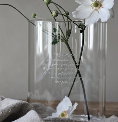Bild av elegant glasvas med vita blommor