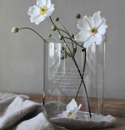 Bild av stilren vas med vita blommor och linnebakgrund