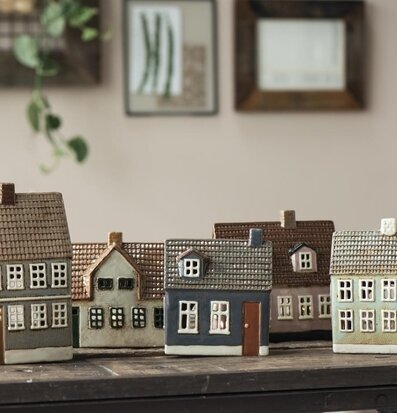 Foto av dekorativa ljuslyktor som föreställer små hus