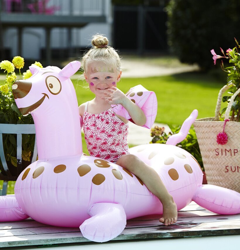 Haj Uppblåsbar Rosa från Rice på en träterrass med växter