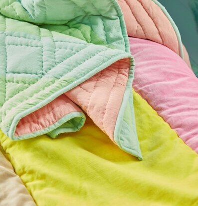 Bomullsfilt Yellow & Pink Stripes från Rice på en möbel