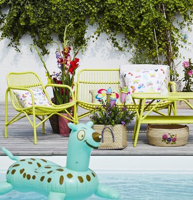 Rice Cane 2 Seater Sofa Soft Yellow med gröna växter