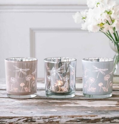Bild av ljuslyktor på rustikt träbord med blommor