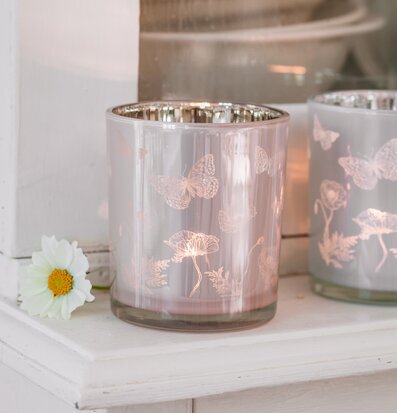 Bild av ljuslykta med fjärilar och vallmo i hemmet