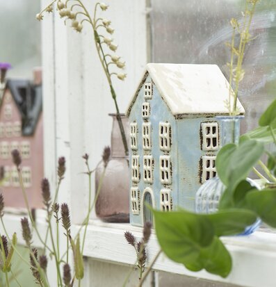 Bild av charmiga husformade ljuslyktor i växthus