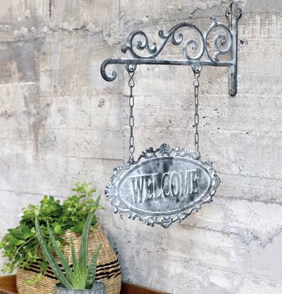 Skylt Welcome Antique Grå från Chic Antique på betongvägg