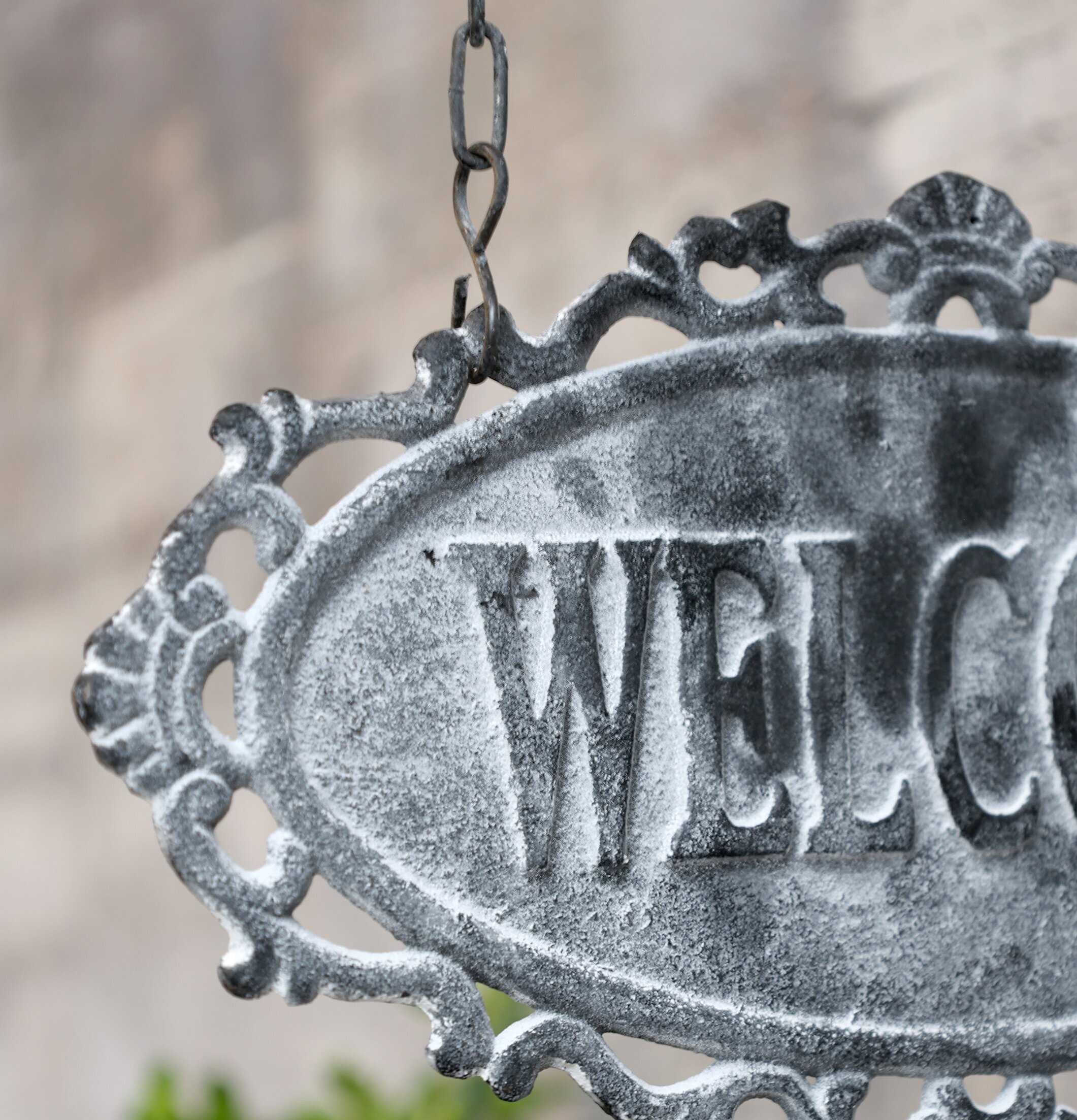 Skylt Welcome Antique Grå från Chic Antique mot stenvägg