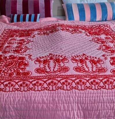 Överkast Pink/Red Embroidery från Rice på en säng med kuddar