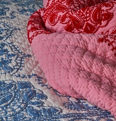 Överkast Pink/Red Embroidery från Rice på en säng