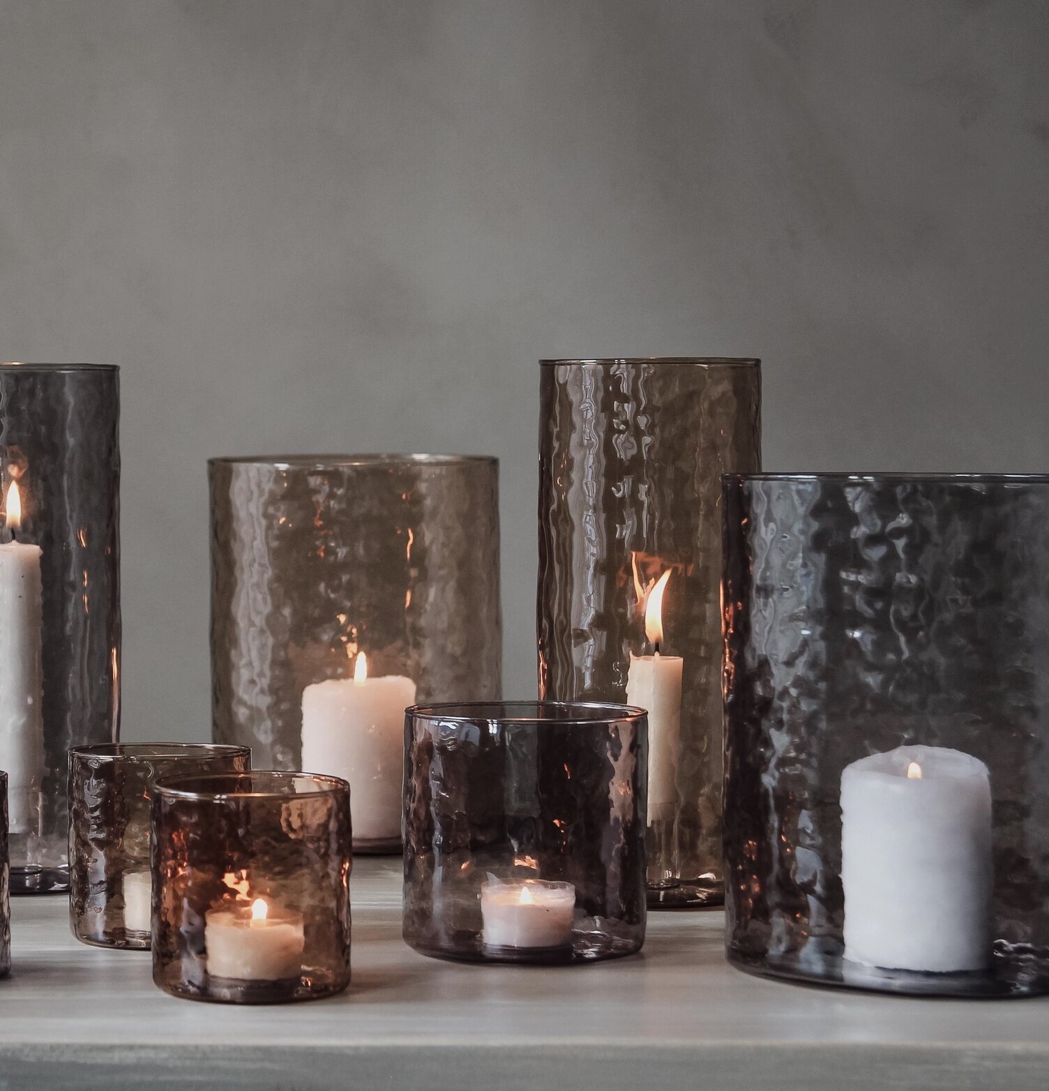 Bild av ljuslyktor i rökfärgat glas och elegant miljö