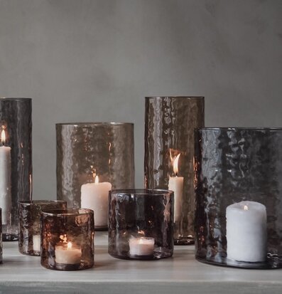Bild av ljuslyktor i rökfärgat glas och elegant miljö