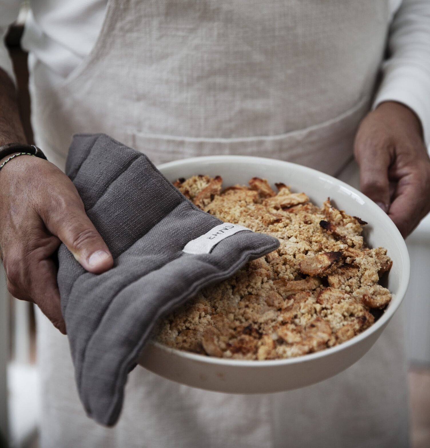 Grytlapp Svart från Ernst i användning med en skål i handen