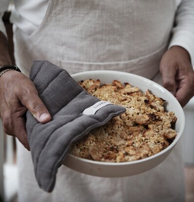 Grytlapp Svart från Ernst i användning med en skål i handen